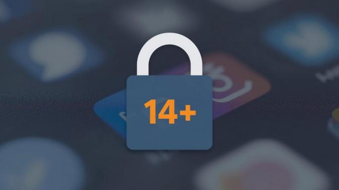 Ein Vorhängeschloss mit der Aufschrift „14+" liegt vor einem unscharfen Hintergrund mit App-Icons auf einem Smartphone-Bildschirm. Das Bild illustriert die geplante österreichische Altersgrenze für die Nutzung von Social-Media-Plattformen.
