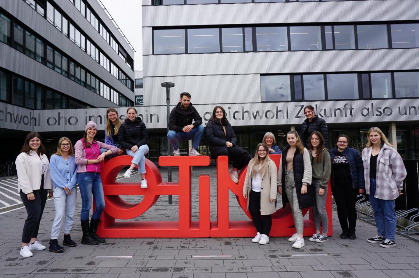 Schüler:innen vor dem PHT Logo