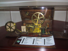 ein Telegraph mit einer davor liegenden Morse Tabelle
