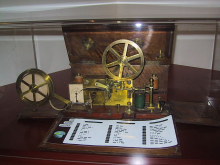 ein Telegraph mit einer davor liegenden Morse Tabelle