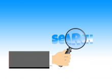 Hand mit Lupe über dem Wort "Search"