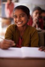 Mädchen lächelnd mit Stift und Heft