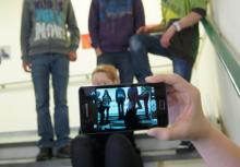 Gruppe von Kindern wird mit einem Smartphone gefilmt