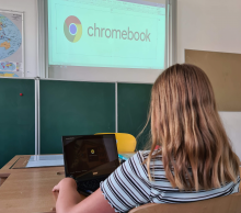 Kind sitzt mit Chromebook in der Klasse