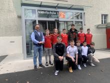 Der frischgebackene Profifußballer Mario Gintsberger (3.v.r. hinten) umringt von Schülern der Sportmittelschule 1 Wörgl und Herrn Direktor Gottfried Schneider, BEd