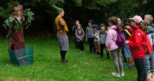 Märchenschauspieler im Wald mit einer Gruppe von Kindern