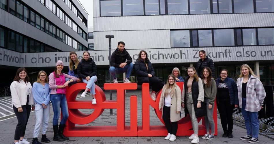 Schüler:innen vor dem PHT Logo
