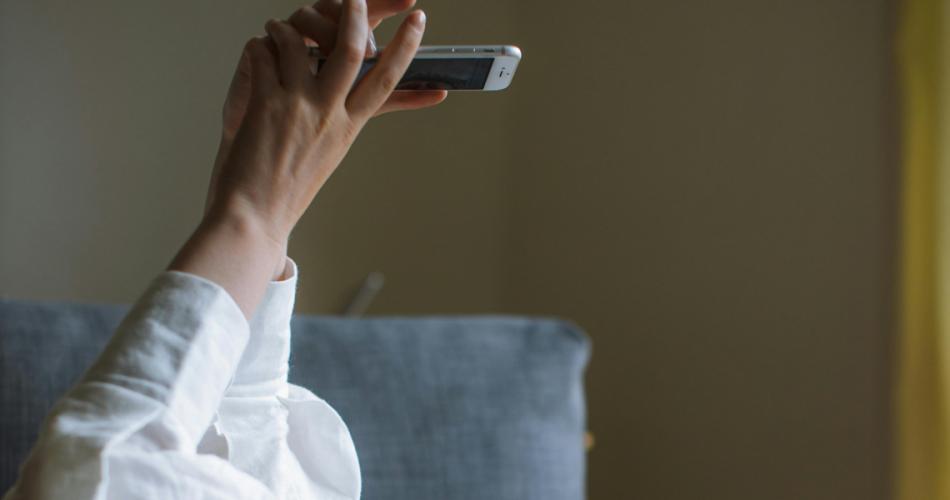 Zwei Hände halten ein Smartphone in die Höhe