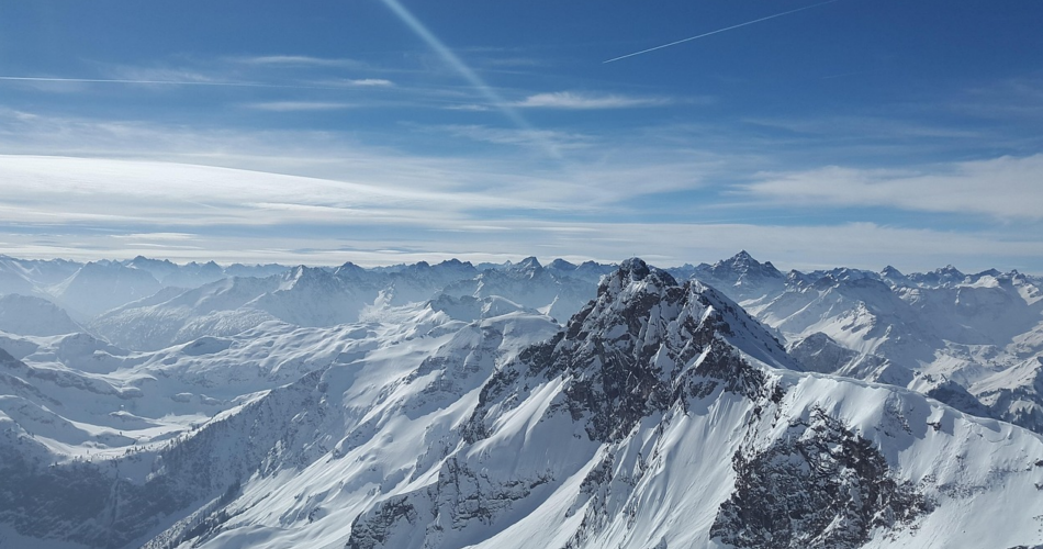 Blick von oben auf mehrere verschneite Berge