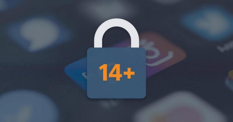 Ein Vorhängeschloss mit der Aufschrift „14+" liegt vor einem unscharfen Hintergrund mit App-Icons auf einem Smartphone-Bildschirm. Das Bild illustriert die geplante österreichische Altersgrenze für die Nutzung von Social-Media-Plattformen.